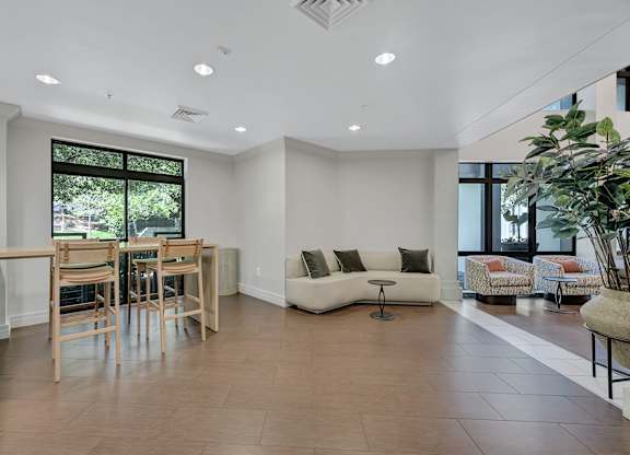 A spacious living room with a dining table and chairs.
