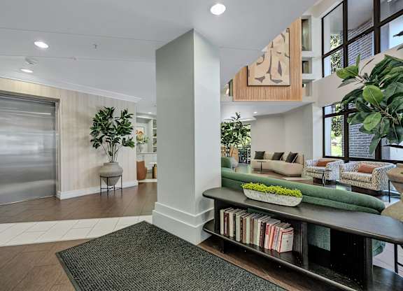 A living room with a couch, a chair, a potted plant, and a fireplace.
