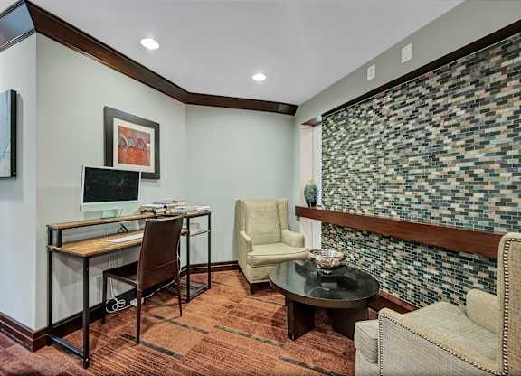A room with a desk, chair, and a couch.