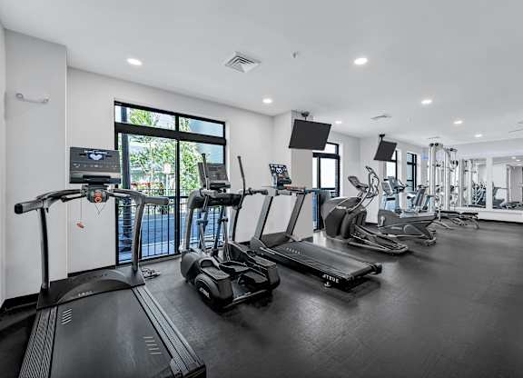 A spacious gym with treadmills, elliptical machines, and other exercise equipment.