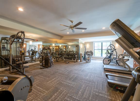 a large fitness room with exercise equipment and a large window
