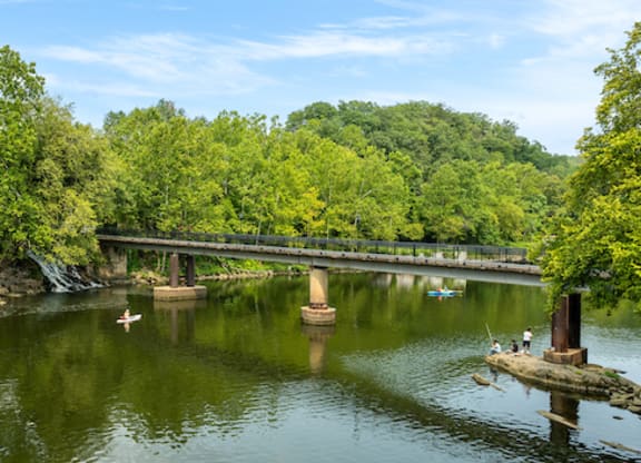 a bridge over a river with people kayaking on it
