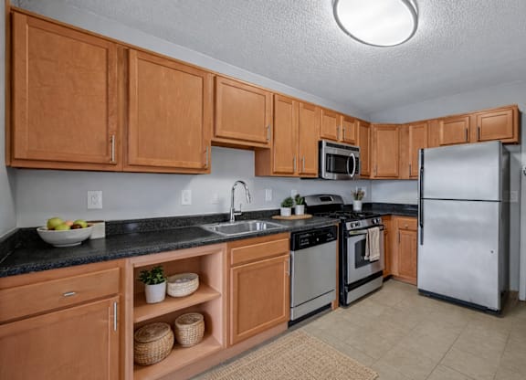 A kitchen with wooden cabinets and a black countertop.