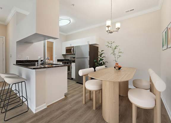 A kitchen with a table and chairs in the middle of the room.