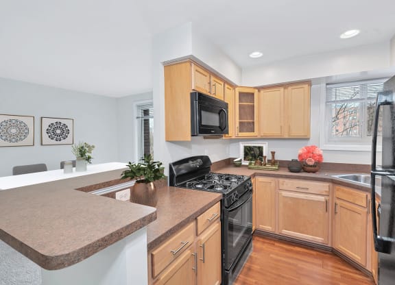 a kitchen with maple cabinets and black appliances