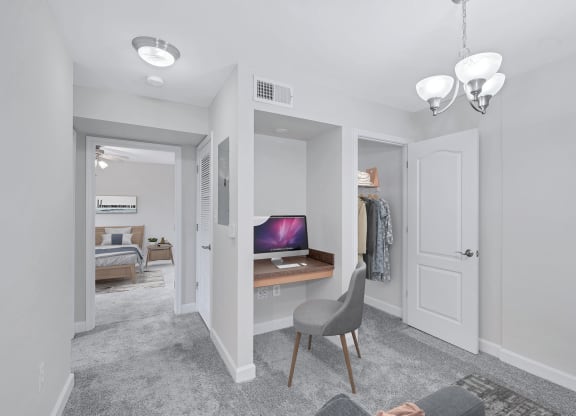 a bedroom with a desk and a closet