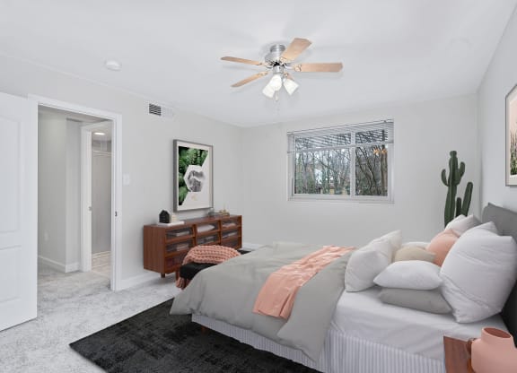 a bedroom with white walls and a white ceiling fan