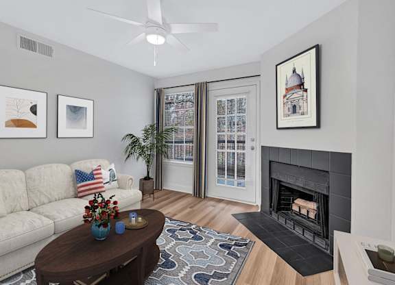 A living room with a fireplace, a couch, a coffee table, and pictures on the wall.
