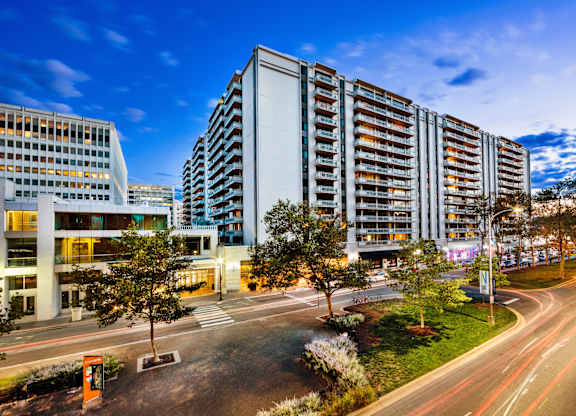 A modern building with a parking lot in front of it.