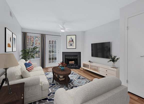A living room with a fireplace, a couch, a chair, a coffee table, and a television.