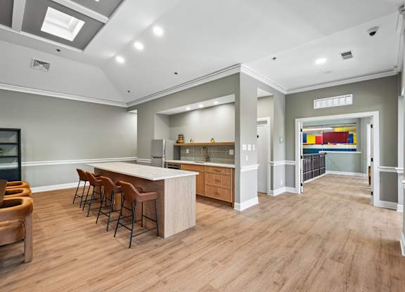 A modern kitchen with wooden floors and a bar area.