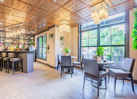 a room with a large window and tables with chairs