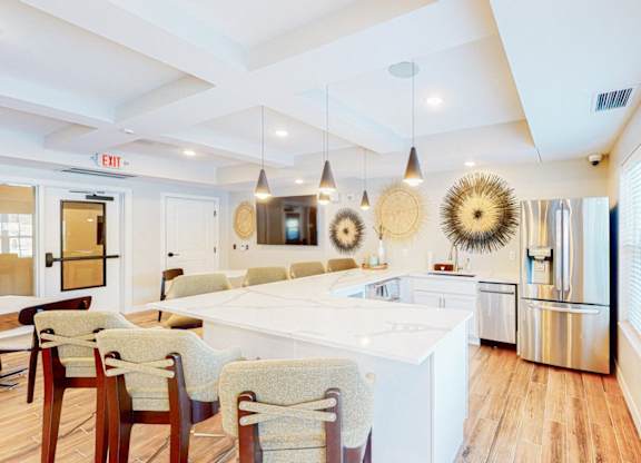 A kitchen with a white island and wooden floors.