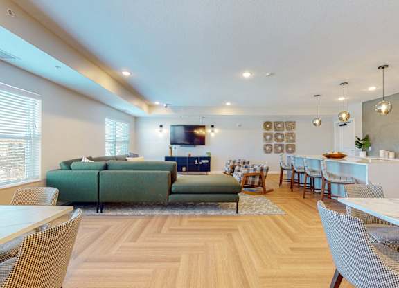 A modern living room with a green sofa and wooden floors.