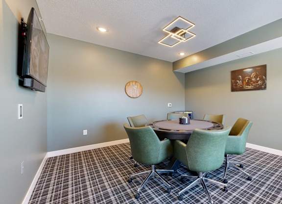 A conference room with a table surrounded by chairs.