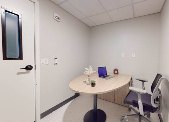 A small room with a round table and a chair.