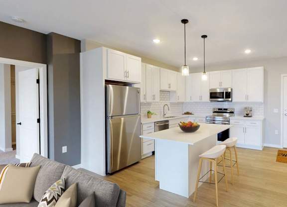 A modern kitchen with a refrigerator, stove, and sink.
