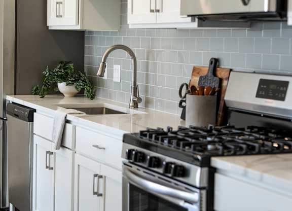 a kitchen with white cabinets and stainless steel appliances