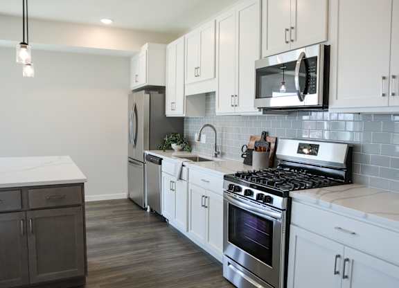 a kitchen with white cabinets and stainless steel appliances