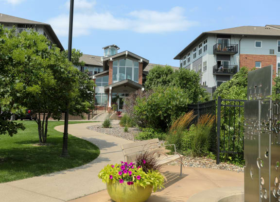 a walkway with benches and buildings in the background