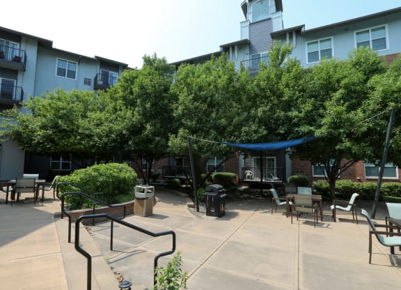 a courtyard with trees and awnings in front of a building