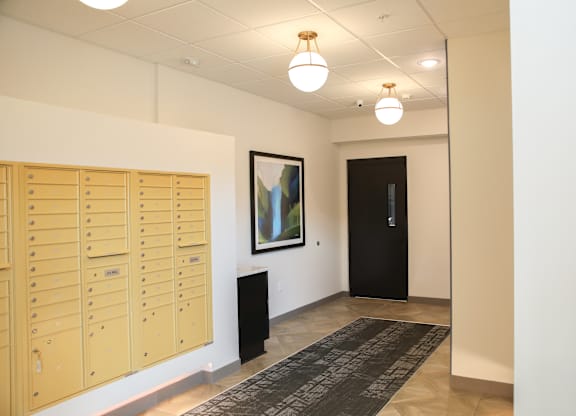 a view of the hallway with lockers and a painting on the wall