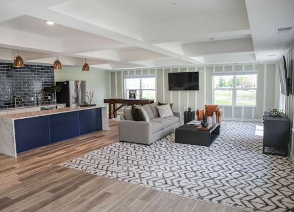 a living room with hardwood floors and a large rug