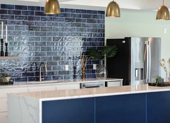 a kitchen with navy blue cabinets and white countertops