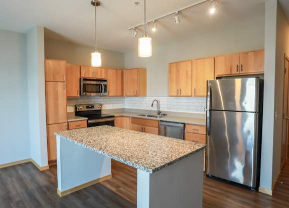 A kitchen with wooden cabinets and a granite countertop.
