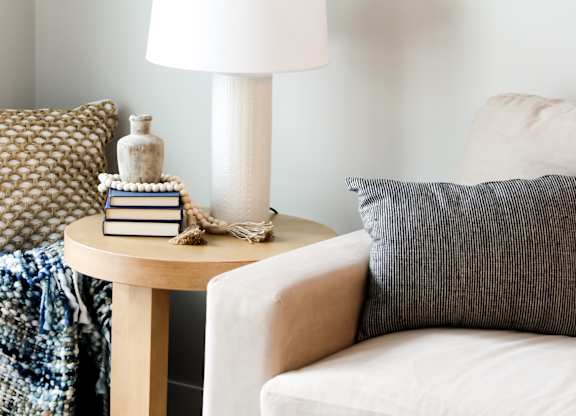 a side table with a lamp and books on it