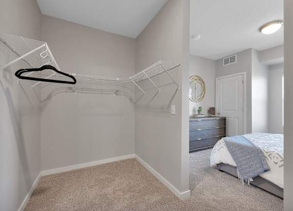 A bedroom with a bed, dresser, and a hanger on the wall.