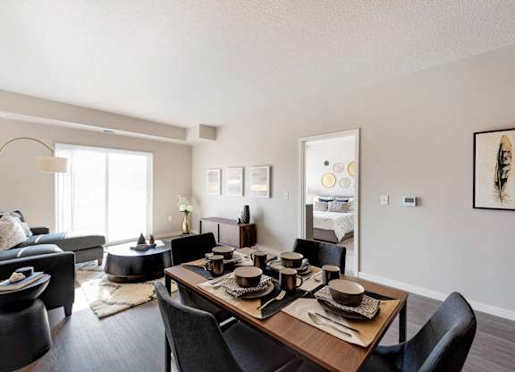 A modern dining room with a wooden table set for four.