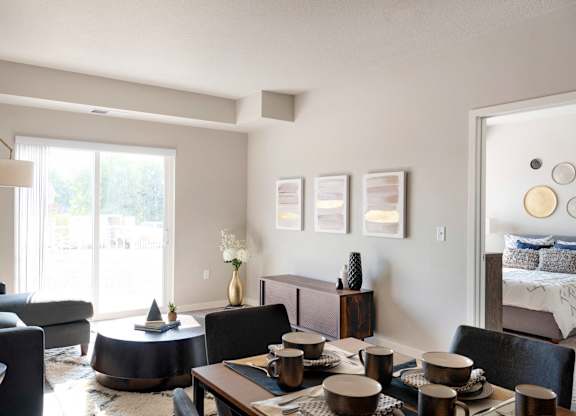 A modern living room with a dining table set for four.