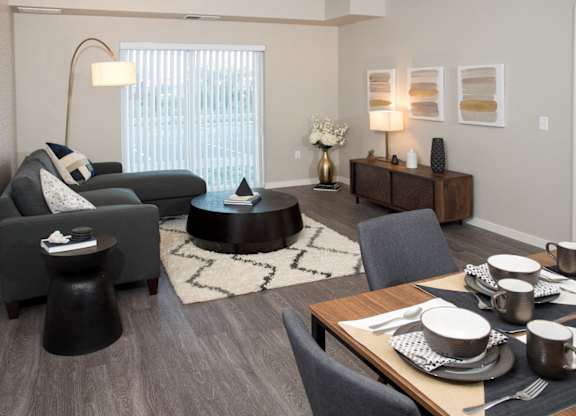 A modern living room with a dining table set for two.