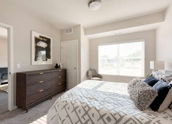 A bedroom with a large bed and a dresser.