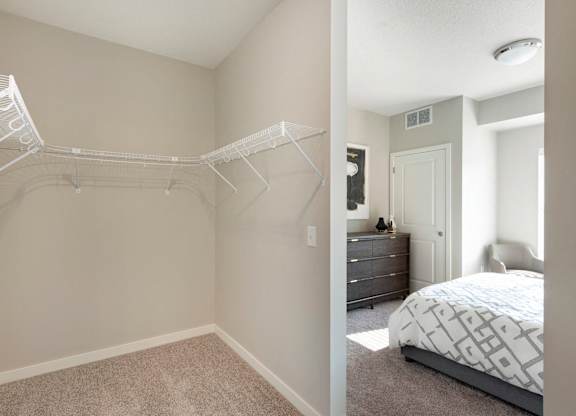 A bedroom with a white bed and a white closet.