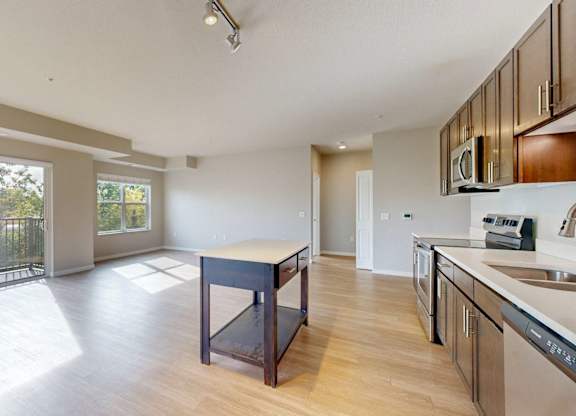 A kitchen with a sink, stove, and microwave.