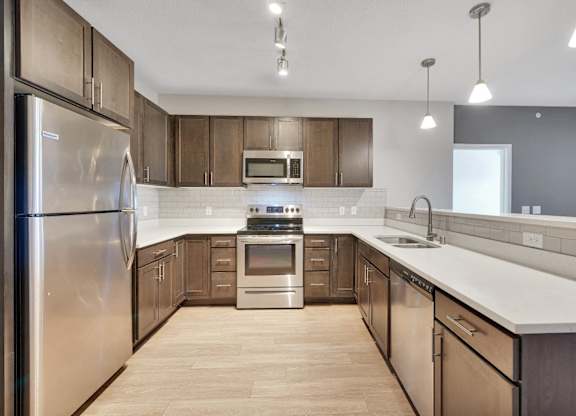 A modern kitchen with wooden cabinets and stainless steel appliances.