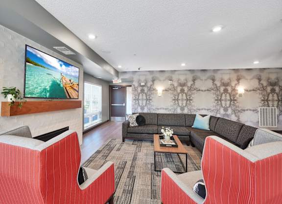 A modern living room with a flat screen TV mounted on a brick wall.