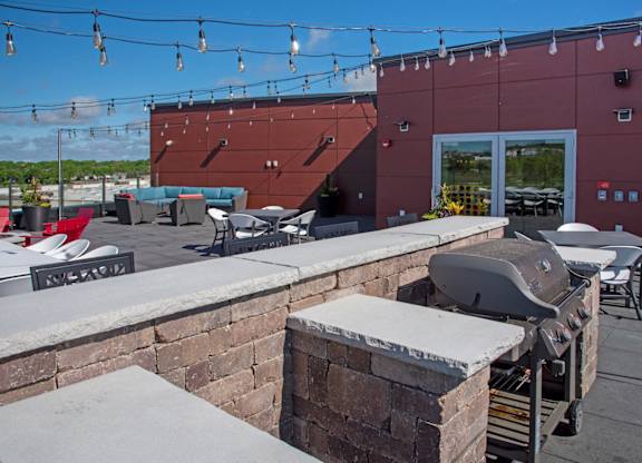 A red building with a grill on the patio.
