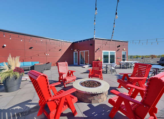 A red patio with chairs and a fire pit.