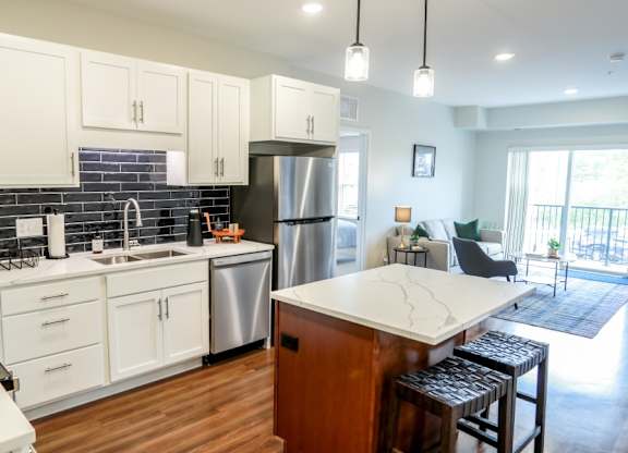 A kitchen with white cabinets and a wooden island.