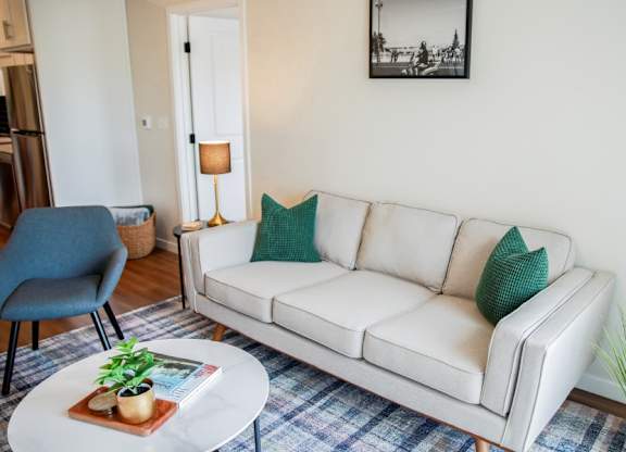 A living room with a white couch and a blue chair.