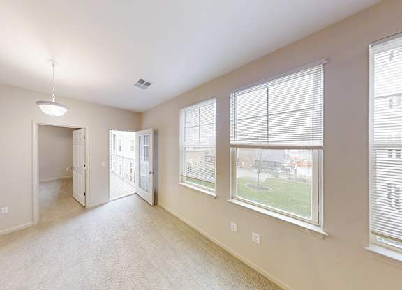 the spacious living room and dining room of an empty home with large windows
