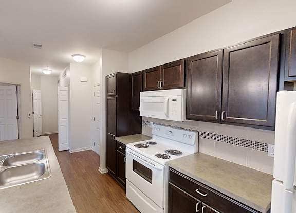 a kitchen with white appliances and dark wood cabinets