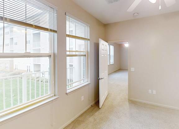 the living room and dining room of an empty home with large windows