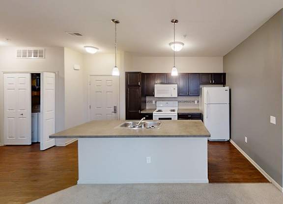 an empty kitchen with a sink and a refrigerator