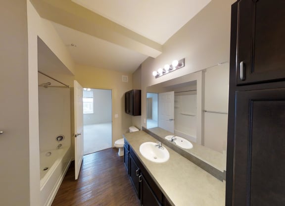 a bathroom with two sinks and a tub and a shower