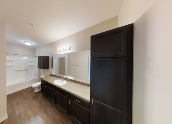 a bathroom with a black cabinet and a sink and a toilet