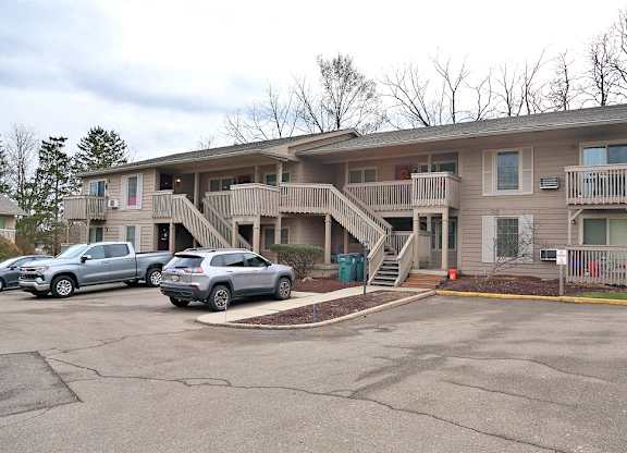 A two-story apartment building with a parking lot in front.